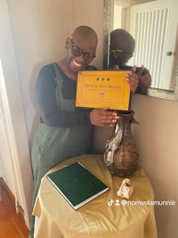 a woman holding a certificate in front of a table